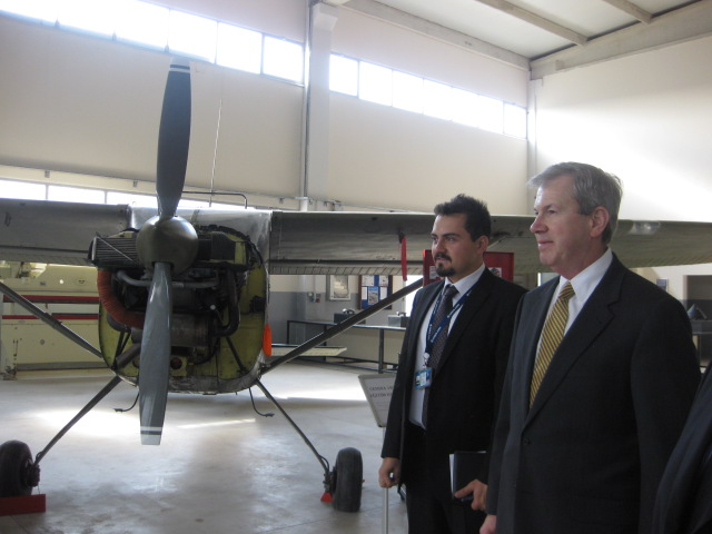 Two men standing in front of a propeller plane