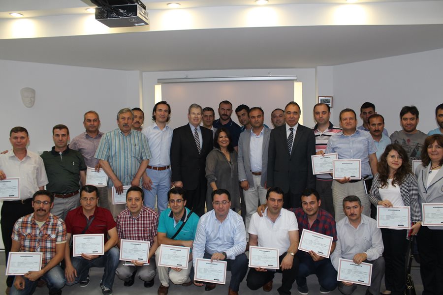 Large group of adults, some holding certificates of honor